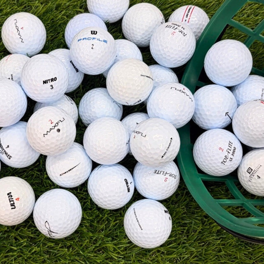 White Golf Balls On Grass Falling out Of a Bucket