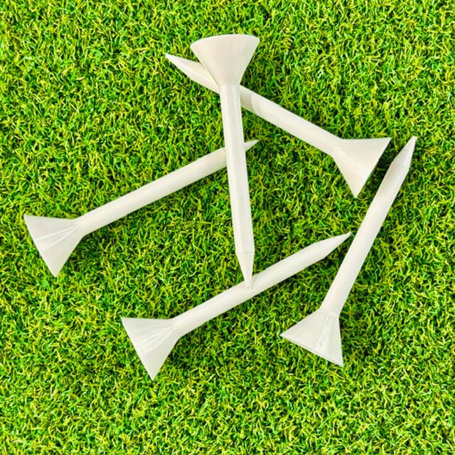 White golf tees on a green grass background