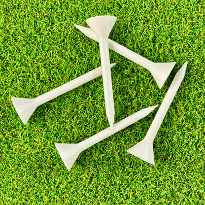 White golf tees on a green grass background